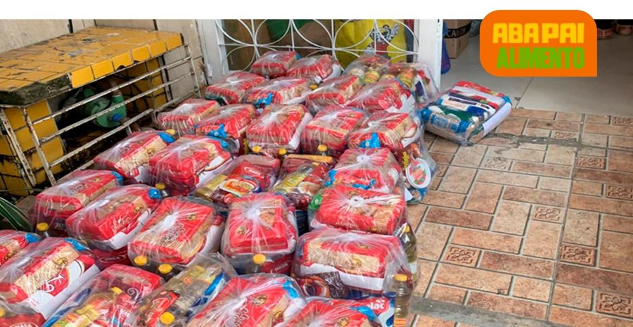 Família recebendo cesta básica do projeto ABA PAI Alimento